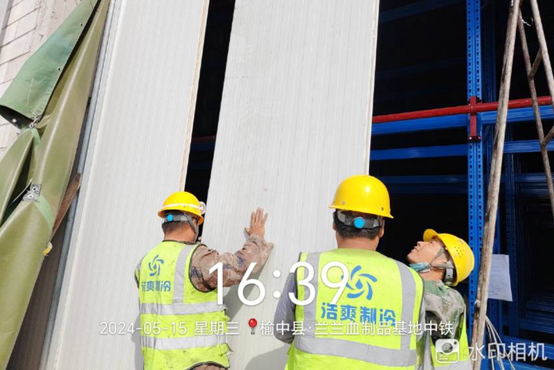 Workers are installing cold storage panels