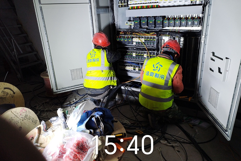 Workers are connecting the wires of the control box