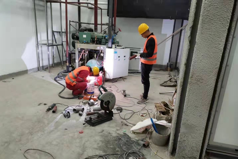 Workers are installing a German Bitzer screw two-parallel compressor unit